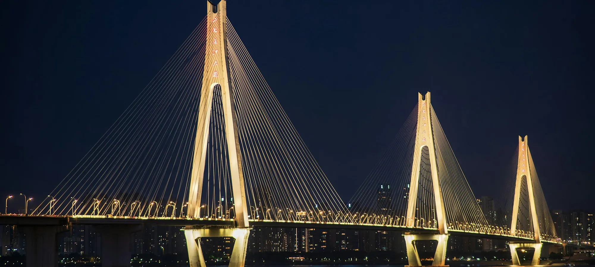 A cable-stayed bridge lit at night