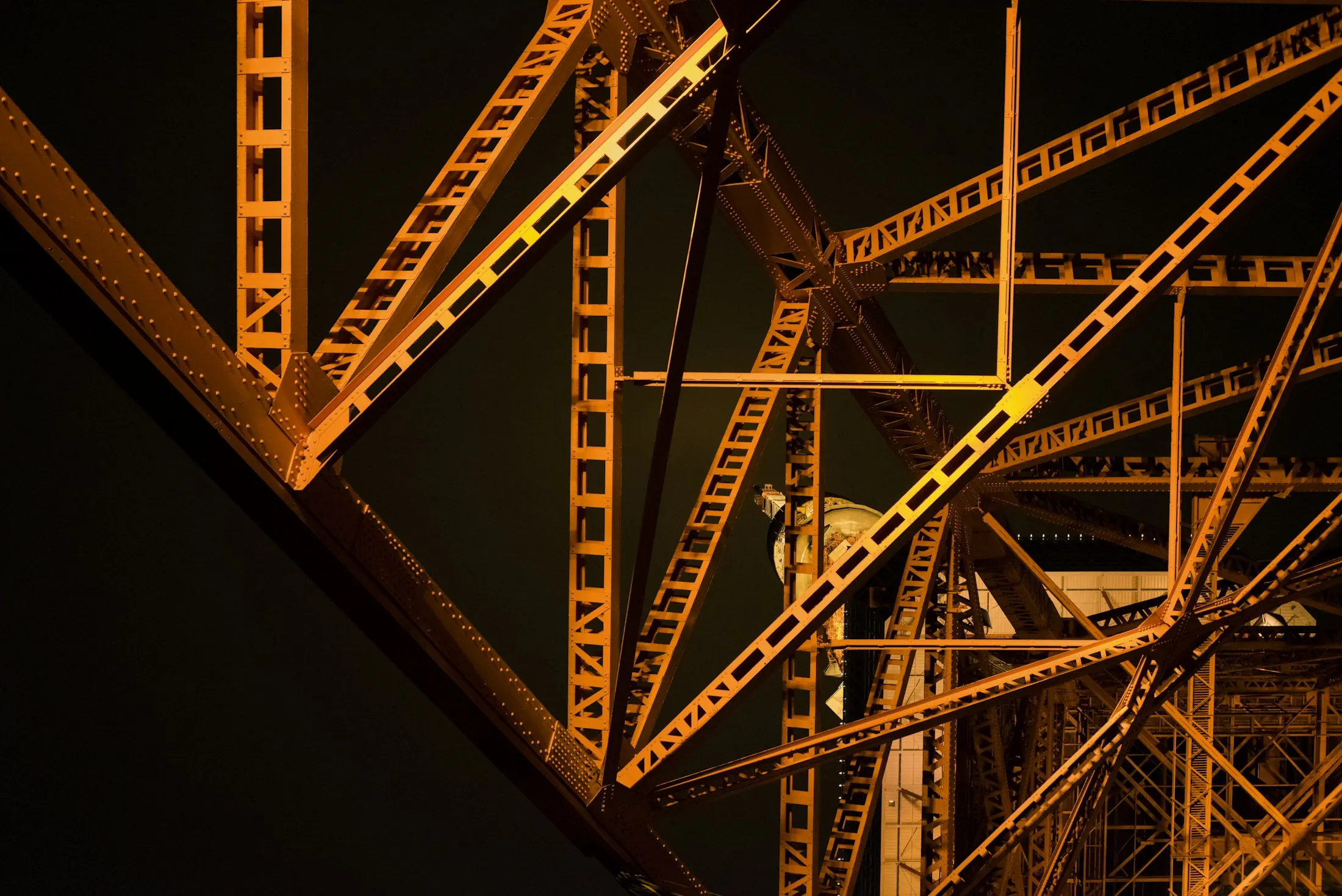 Illuminated steel girders against a night sky